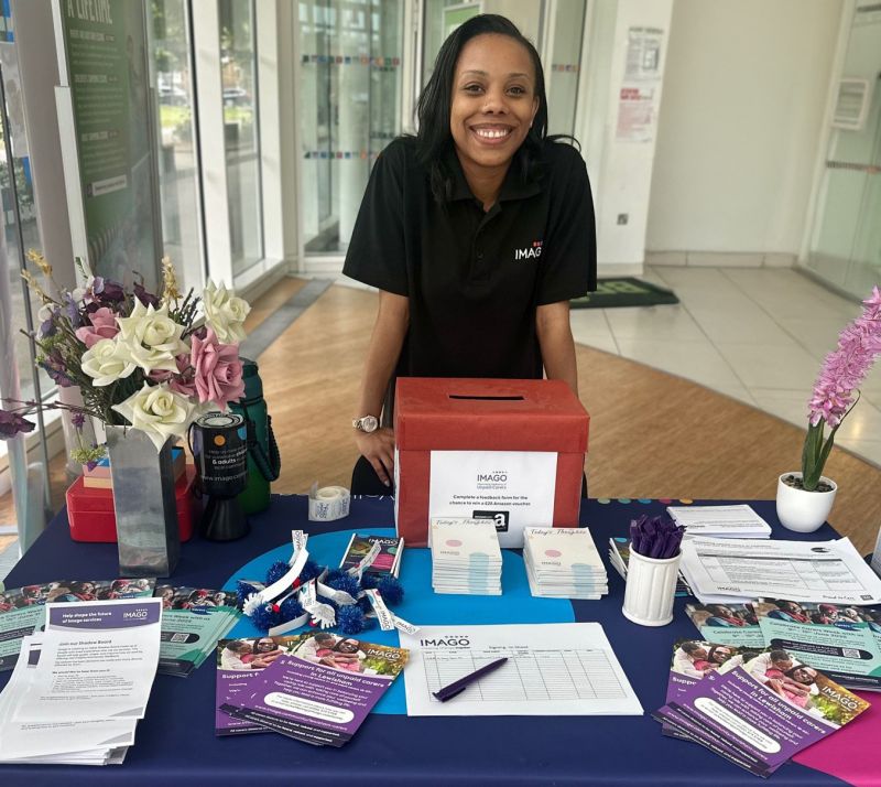 Photo of Imago staff member welcoming people to an event
